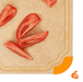 Close-up of an Elihome wood fiber cutting board featuring a juice groove and an orange non-slip silicone corner, shown with sliced tomatoes.
