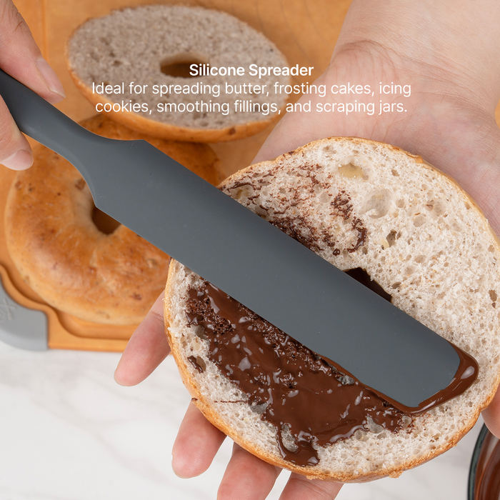 Elihome x Peanuts Silicone Spreader from the 8 piece set spreading chocolate on a bagel half